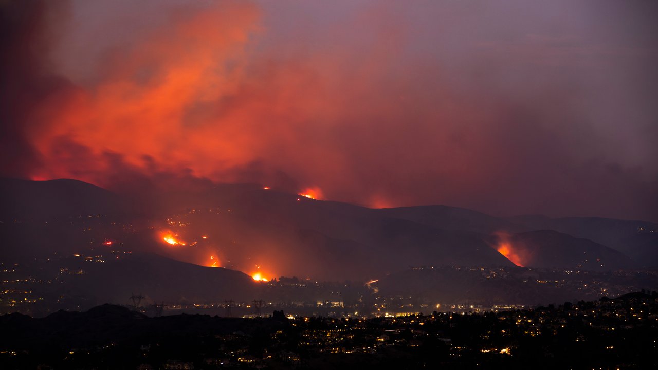 A nighttime wildfire tears through the hills in California