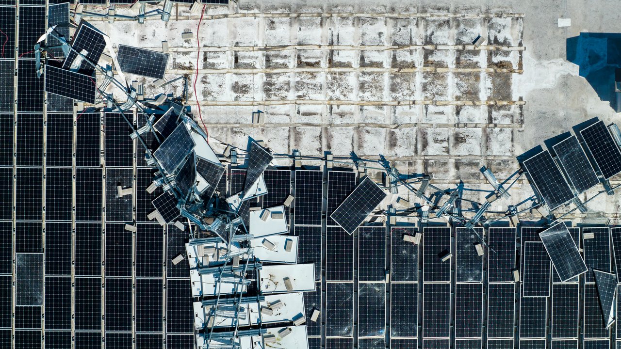 Aerial view of destroyed solar panels mounted on roof Aerial view of destroyed solar panels mounted on roof