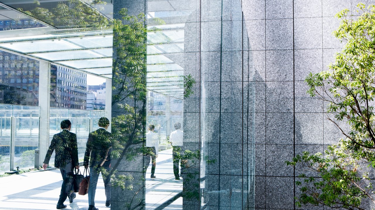 Physical risk is changing real estate value, and insurance terms make it visible. business men in office building